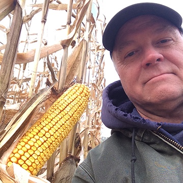 Max posing next to corn stalk