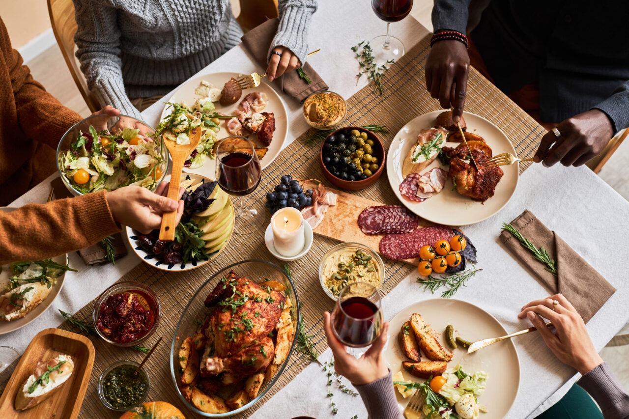 Diverse group of friends enjoying homemade food at dinner table