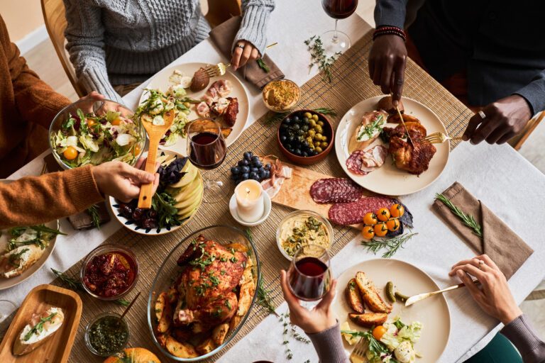 Diverse group of friends enjoying homemade food at dinner table