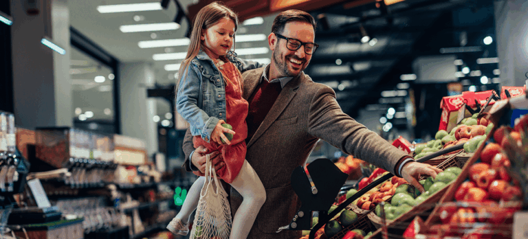 Dad holding daughter in grocery store