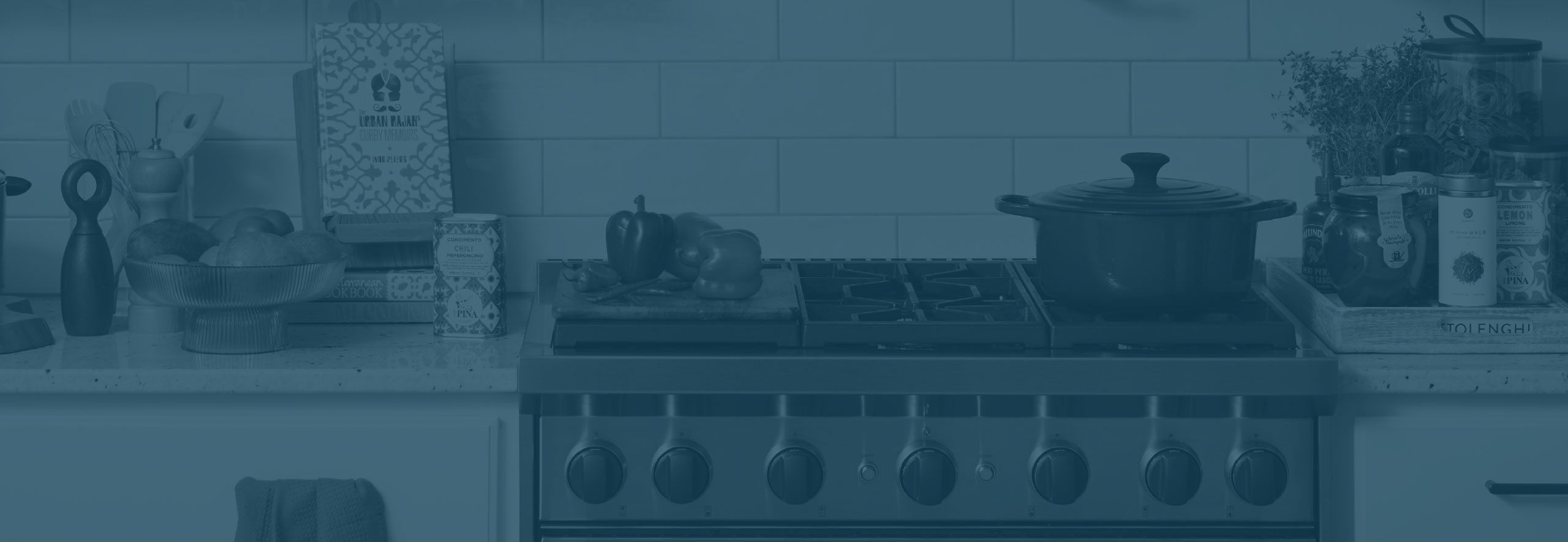 Photo of a kitchen with cookware, fresh produce, and a cookbook